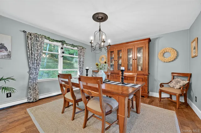 a dining room with furniture a chandelier and wooden floor