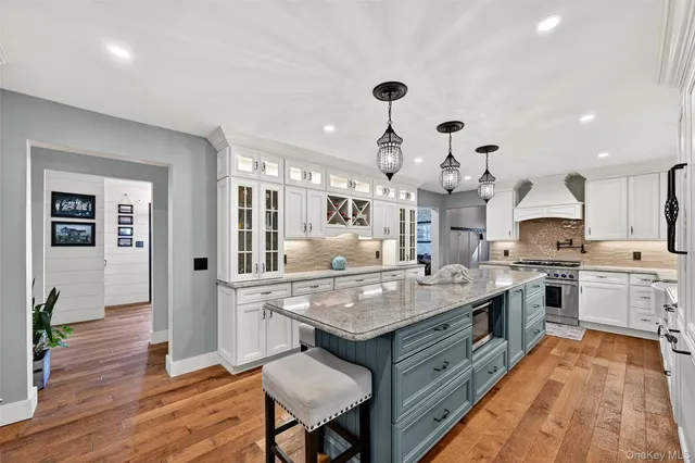 a kitchen with granite countertop a stove and white cabinets