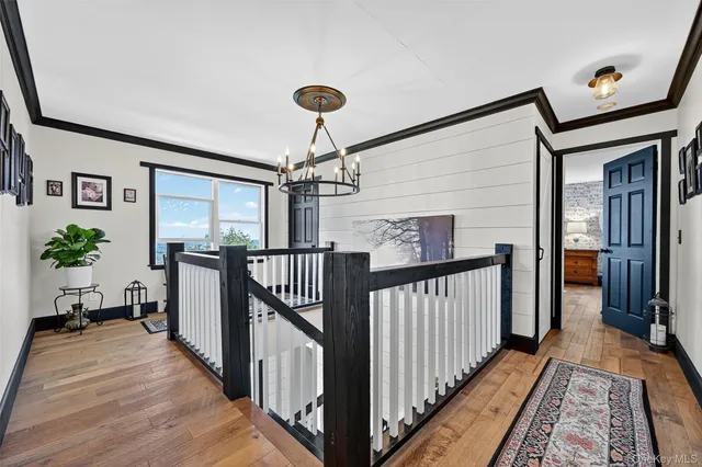 a view of hallway with wooden floor and stairs