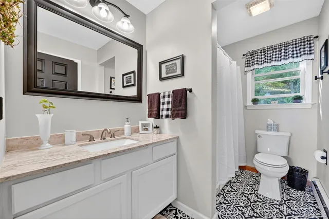 a bathroom with a granite countertop toilet sink and a mirror