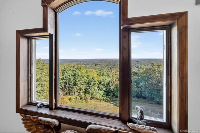 a view of a room that has a large window and front door