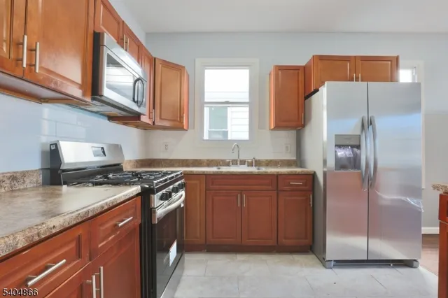 a kitchen with stainless steel appliances granite countertop a stove a refrigerator and a sink
