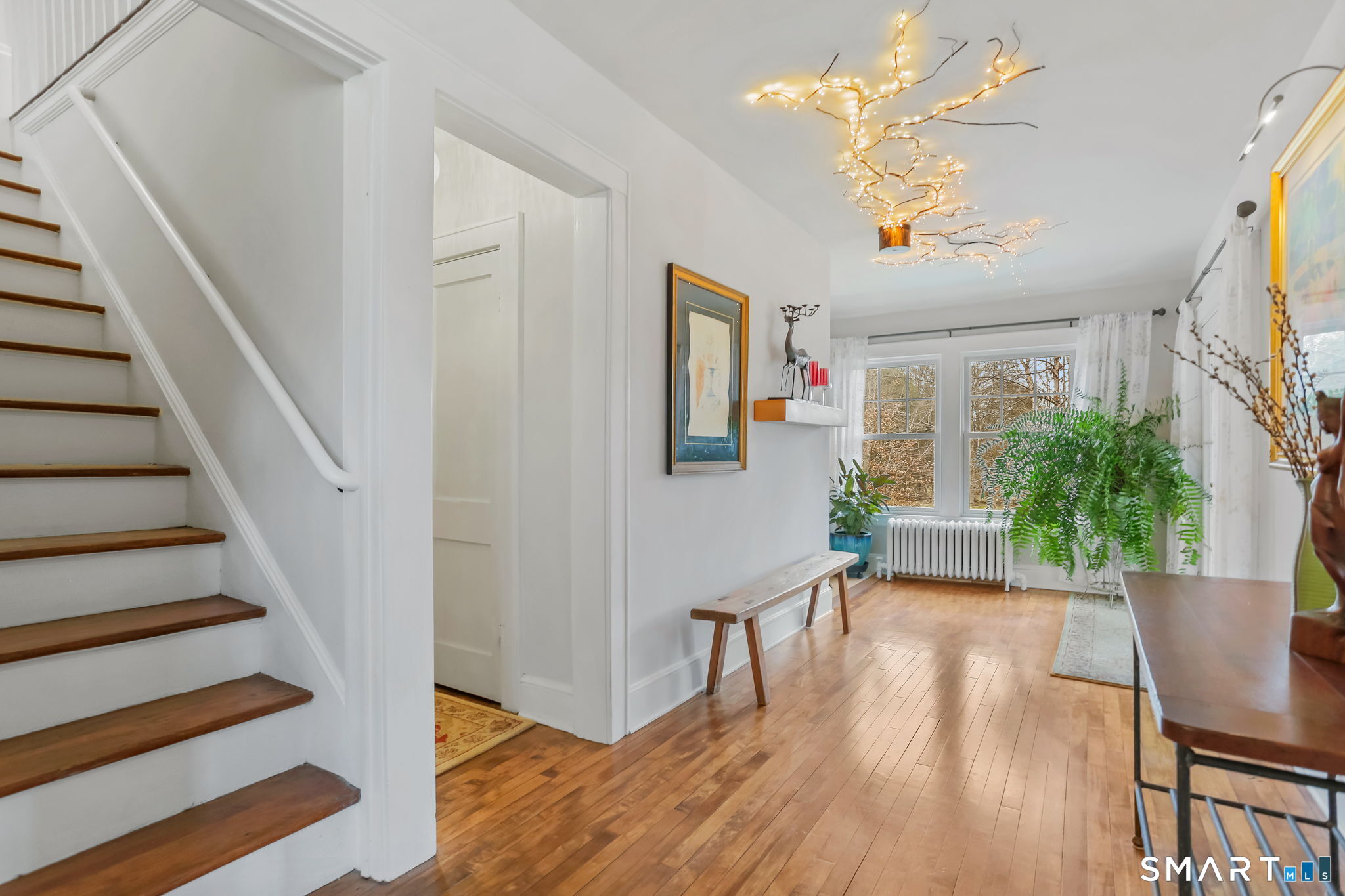 98 Comstock Hill Avenue Norwalk, CT 06850 - Photo 12 of 40 a view of a hallway with wooden floor and a chandelier