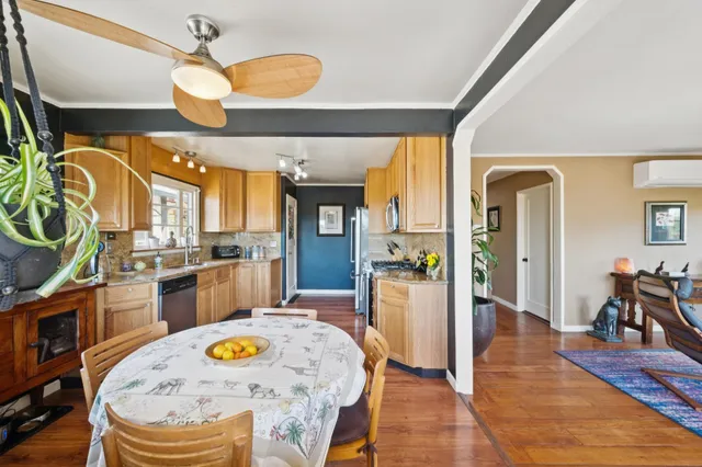 a dining room with wooden floor and chandelier