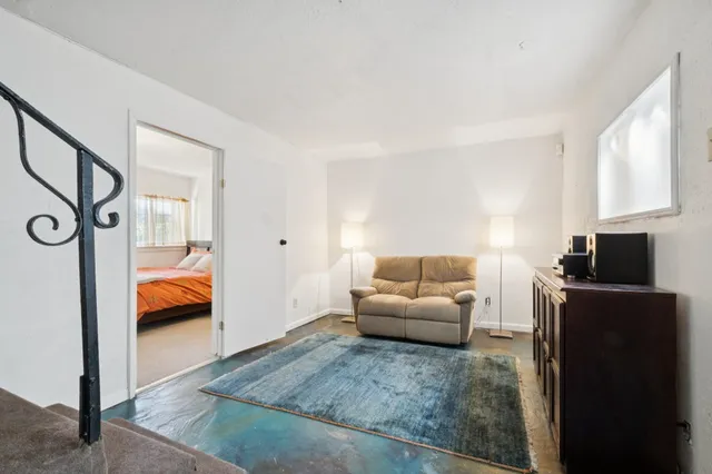a bedroom with a bed and a flat tv screen on wall