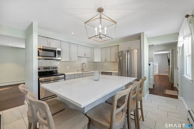 a kitchen with a table chairs refrigerator and microwave