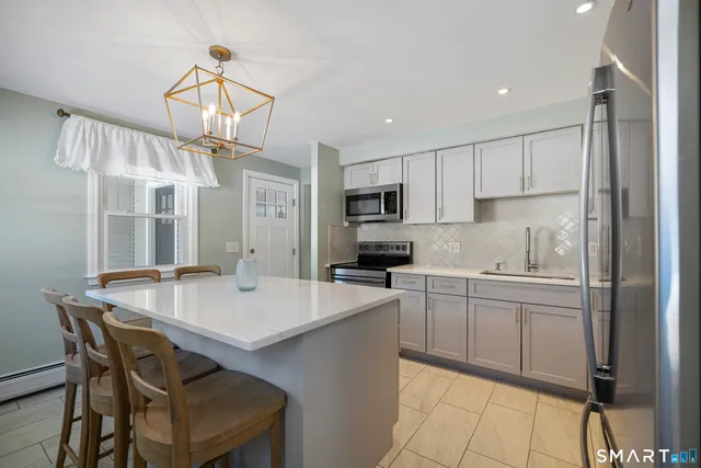 a kitchen with a table chairs microwave and cabinets
