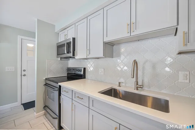 a kitchen with white cabinets and a sink