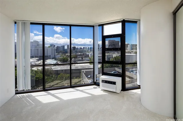 a view of an empty room with window and a livingroom