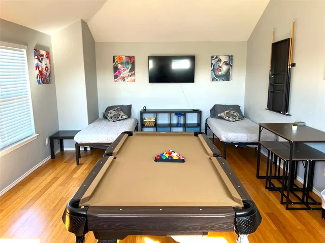 a living room with furniture pool table and a window