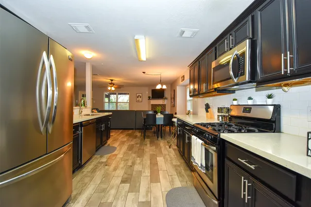 a kitchen with stainless steel appliances a refrigerator a stove and a sink