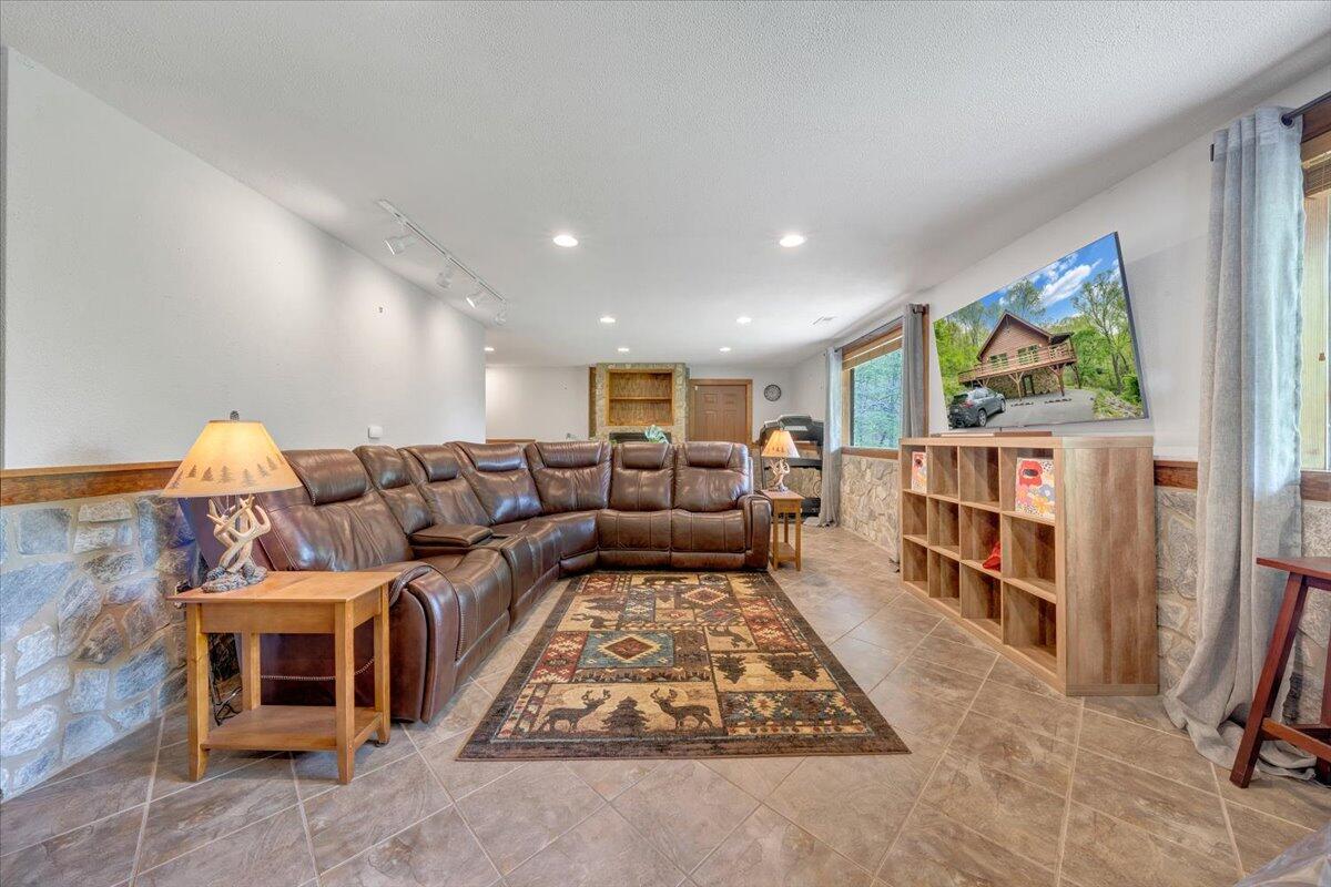 13357 Callaway Road Callaway, VA 24067 - Photo 35 of 62 a living room with furniture a flat screen tv and a floor to ceiling window
