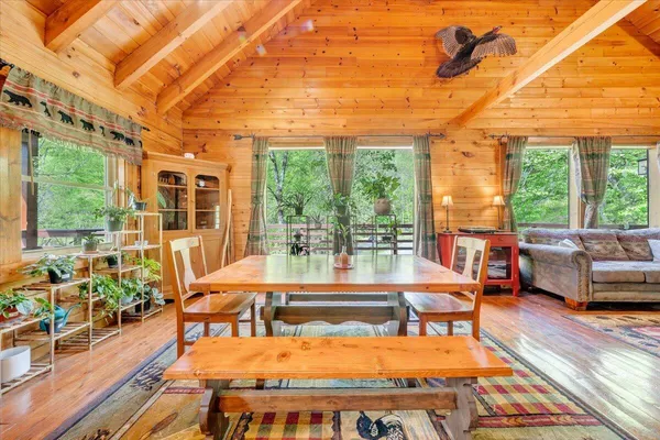 a view of a patio with couches table and chairs with wooden floor