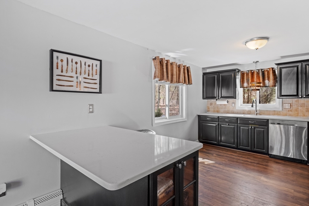 40 Gaita Drive Derry, NH 03038 - Photo 11 of 34 a kitchen with stainless steel appliances a kitchen island hardwood floor sink stove and wooden cabinets