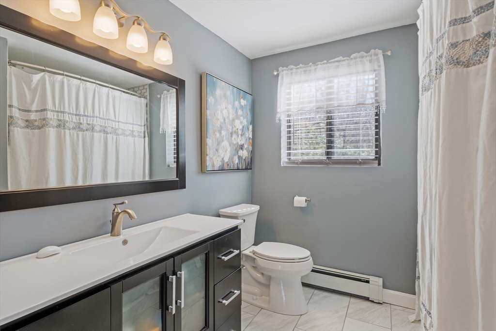 40 Gaita Drive Derry, NH 03038 - Photo 25 of 34 a bathroom with a granite countertop sink toilet a large mirror and a window