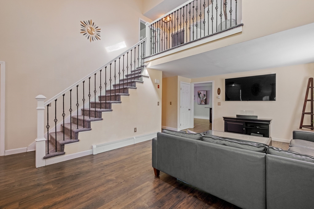 40 Gaita Drive Derry, NH 03038 - Photo 10 of 34 a living room with stairs and a flat screen tv