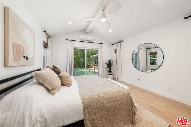 a bedroom with a bed mirror and window