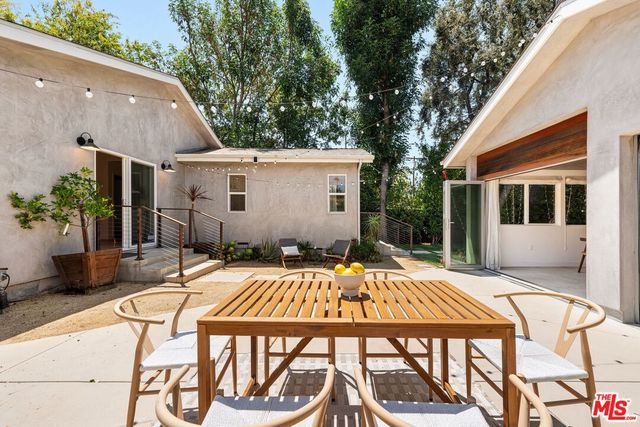 a view of house with backyard and sitting area