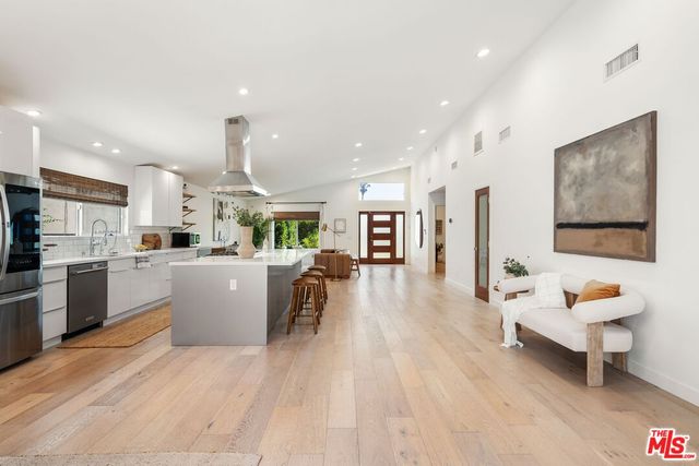 a living room with furniture and kitchen view