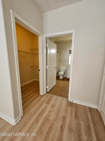 a view of a room with wooden floor and a bathroom