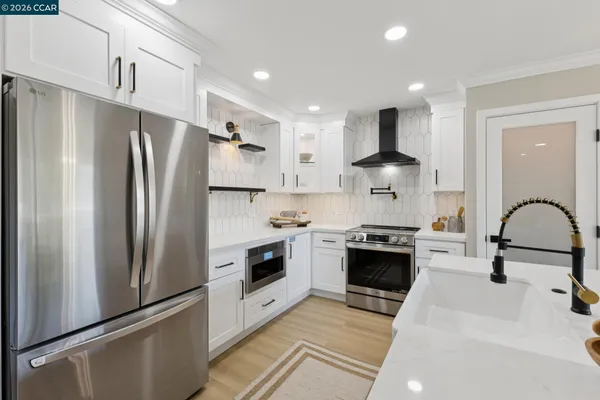 a kitchen with stainless steel appliances a refrigerator sink and stove