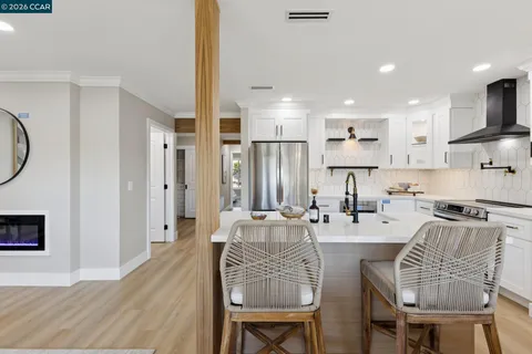 a kitchen with stainless steel appliances a refrigerator a stove and white cabinets