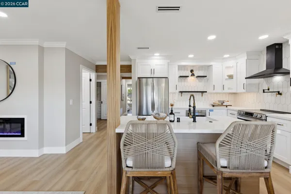 a kitchen with stainless steel appliances a refrigerator a stove and white cabinets