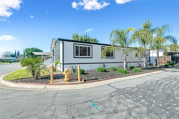 a front view of a house with a yard and potted plants
