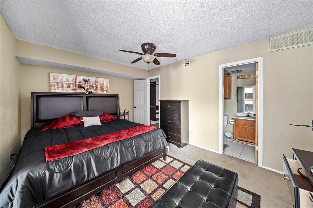 9811 Walnut Street, Unit 201 Dallas, TX 75243 - Photo 11 of 15 a bedroom with a bed and a chandelier