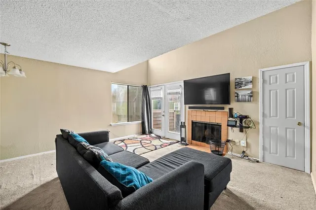 a living room with furniture a flat screen tv and a fireplace