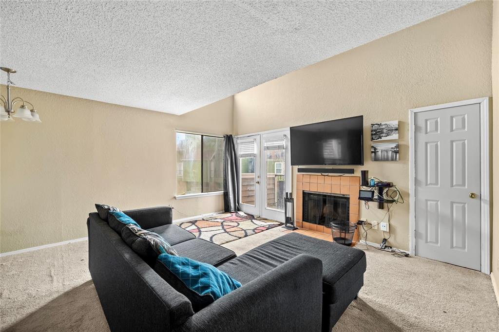 9811 Walnut Street, Unit 201 Dallas, TX 75243 - Photo 4 of 15 a living room with furniture a flat screen tv and a fireplace