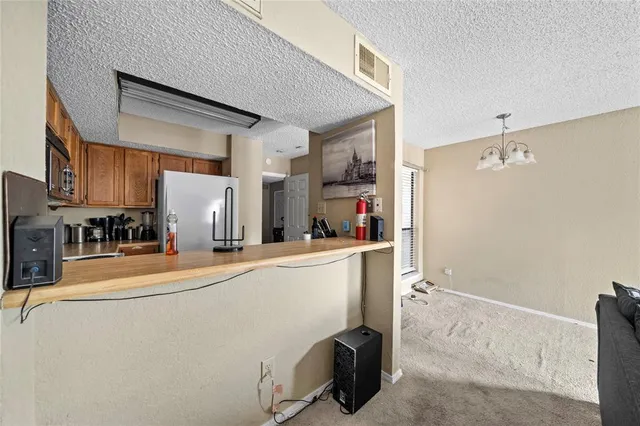a room with stainless steel appliances a refrigerator and a cabinets