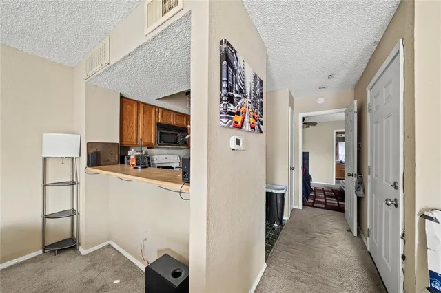 a view of a hallway with workspace and living room