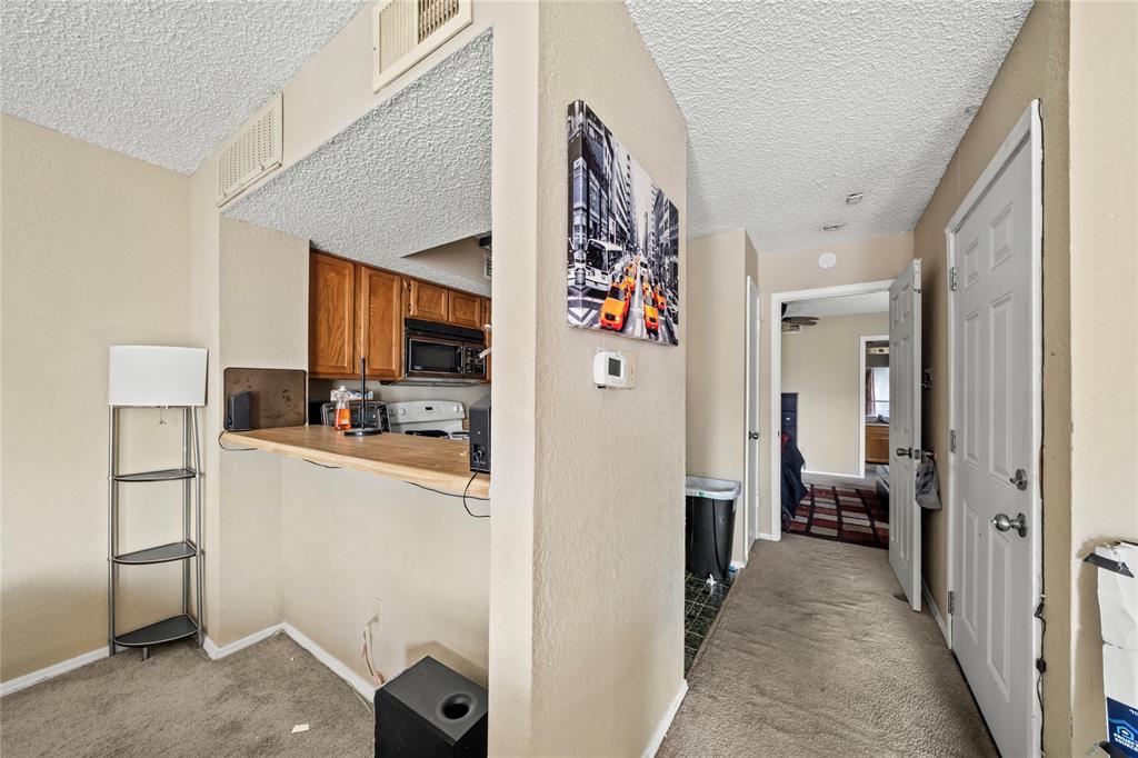 9811 Walnut Street, Unit 201 Dallas, TX 75243 - Photo 6 of 15 a view of a hallway with workspace and living room