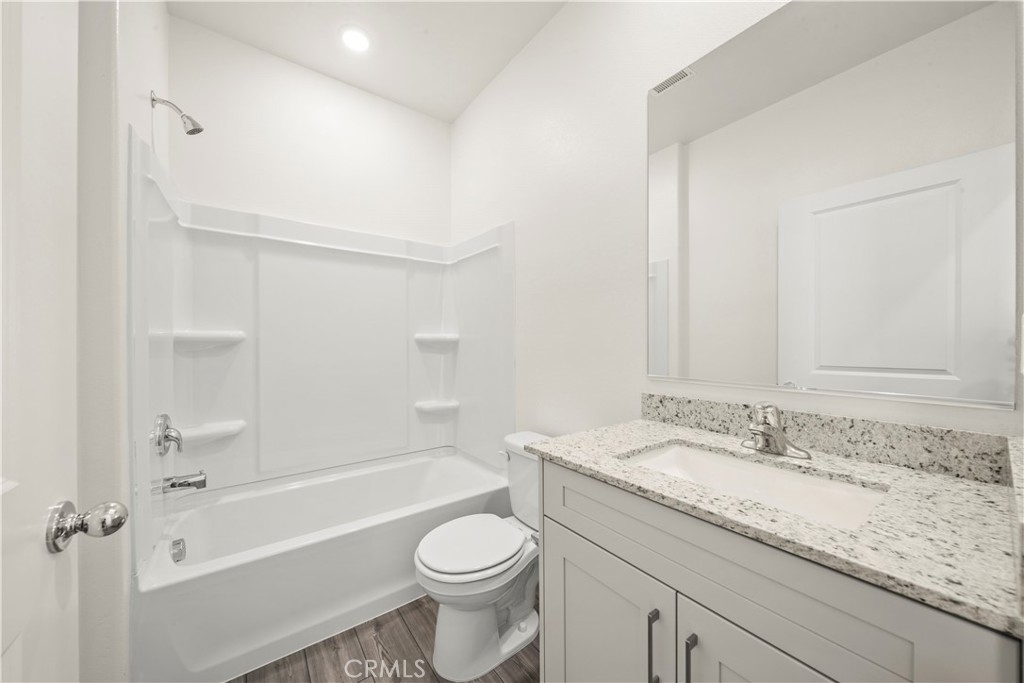 42484 Isla Court Indio, CA 92201 - Photo 12 of 16 a bathroom with a granite countertop sink a toilet and bathtub