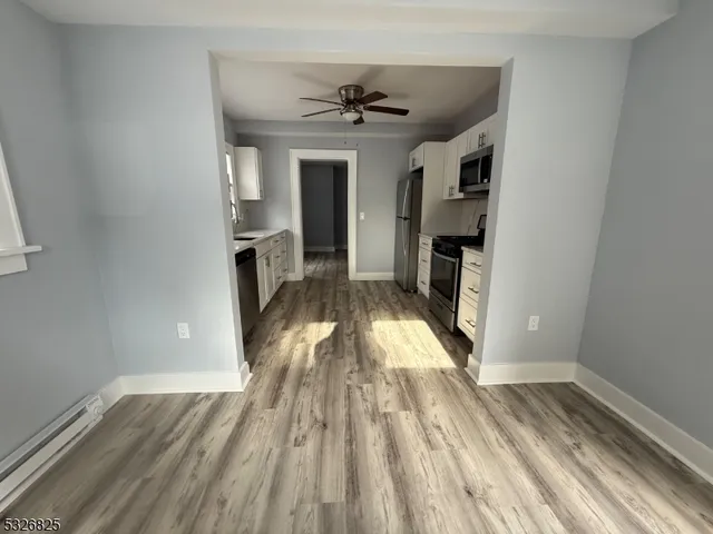 a view of a livingroom with wooden floor and a ceiling fan