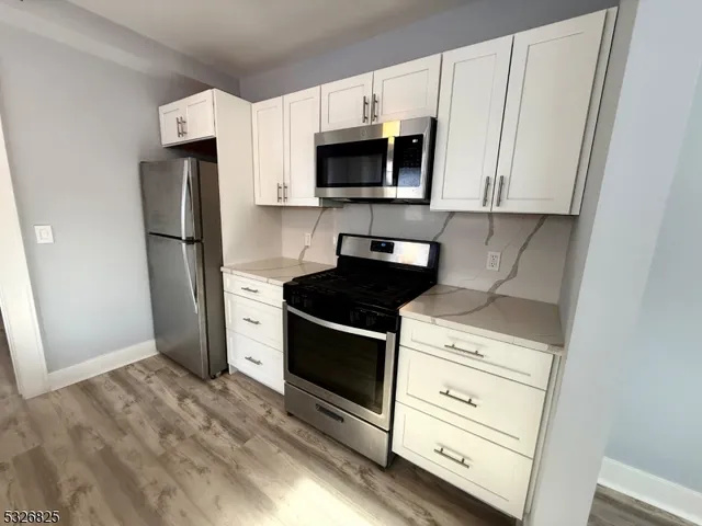 a kitchen with white cabinets and stainless steel appliances