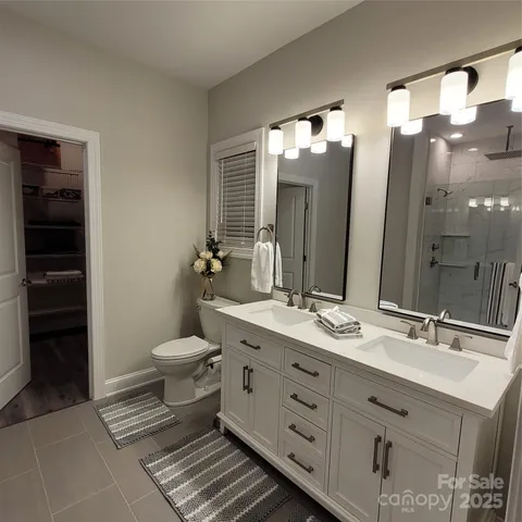 a bathroom with a double vanity sink a toilet and a mirror