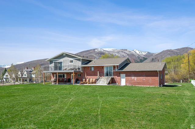 550 Pine Canyon Road Midway, UT 84049 - Photo 35 of 44 Expansive green lawn with a two-story residence featuring a brick facade and gray siding