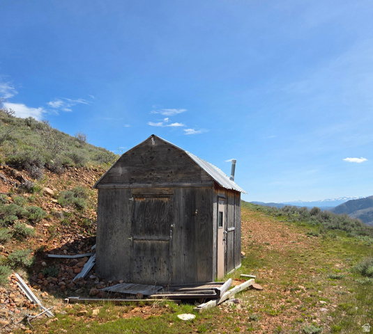 3325 North Oak Cyn Road, Unit 490 Huntsville, UT 84317 - Photo 12 of 25 Rustic wood-sided structure with a gabled metal roof and a prominent chimney vent