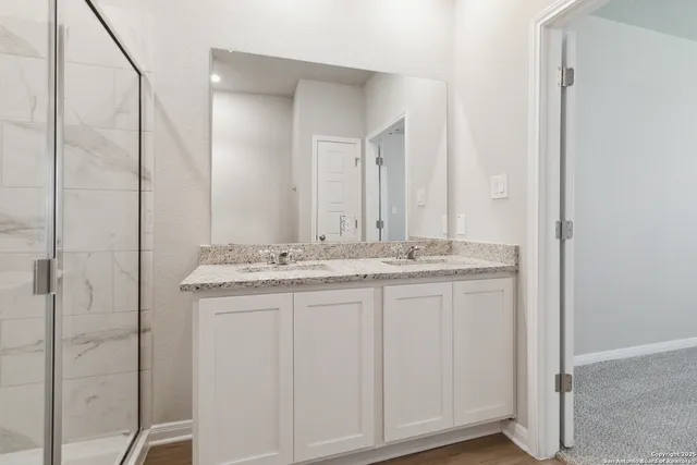a bathroom with a granite countertop sink and a mirror