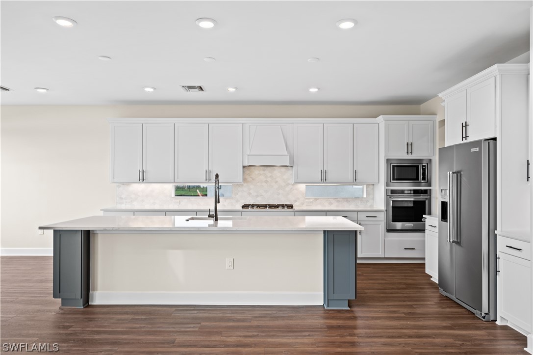 42548 Little Ridge Road Punta Gorda, FL 33982 - Photo 5 of 50 a kitchen with kitchen island white cabinets and stainless steel appliances