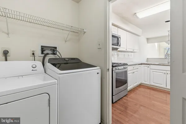 a kitchen with a stove white cabinets and white appliances