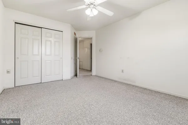 an empty room with fan and entrance