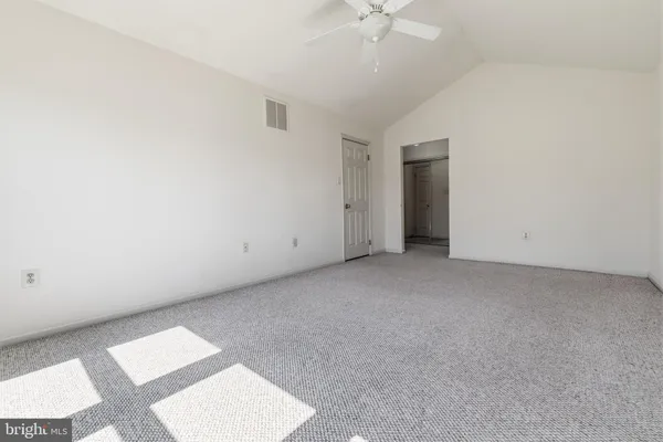 a view of an empty room with a chandelier fan