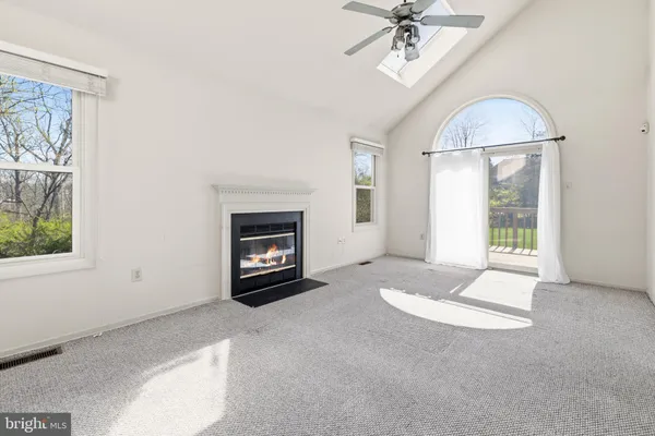 an empty room with windows and fireplace