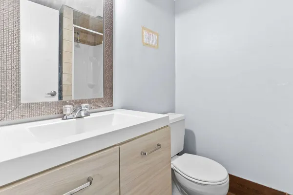 a bathroom with a sink a toilet a mirror and vanity