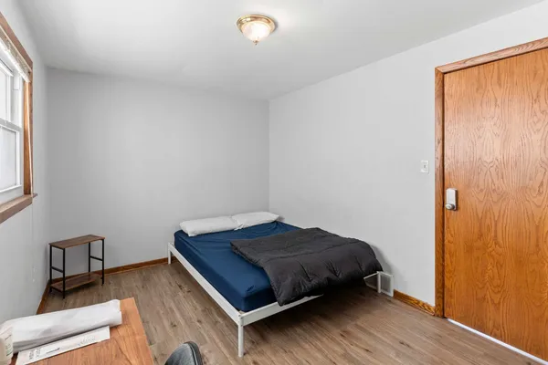 a bedroom with a bed and wooden floor