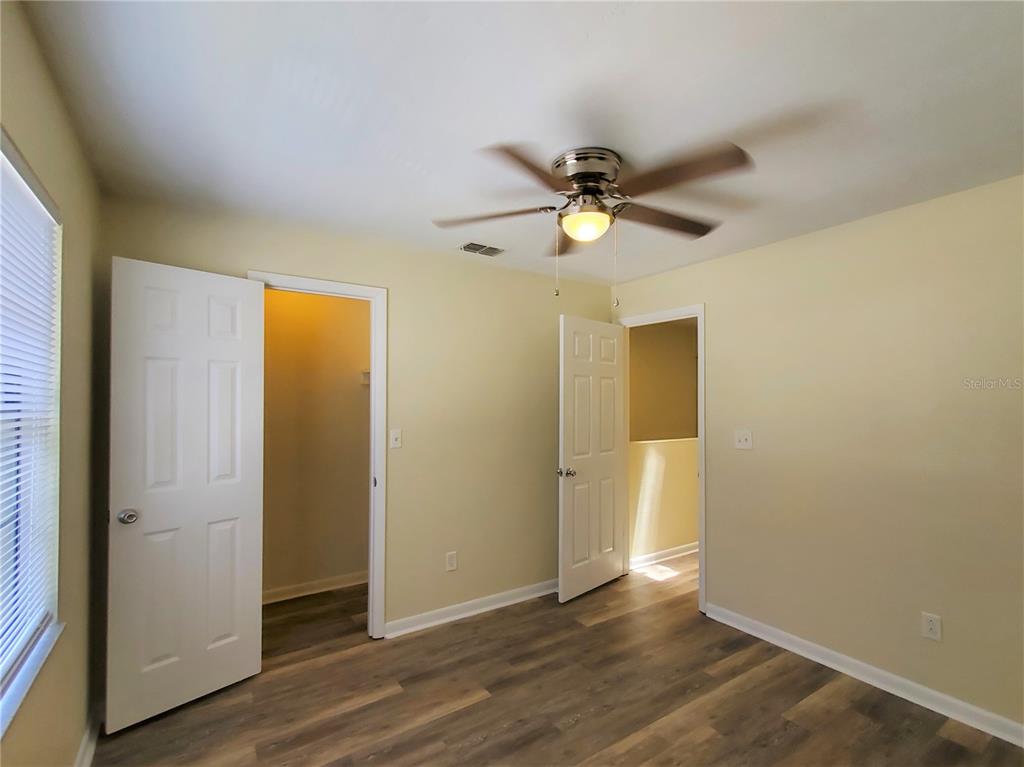 2207 Southwest 39 Drive Gainesville, FL 32607 - Photo 19 of 22 an empty room with wooden floor and a ceiling fan