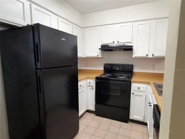 a kitchen with a refrigerator stove and white cabinets